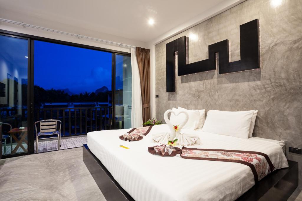 a bedroom with a large bed and a balcony at Aonang Viva Resort - SHA Plus in Ao Nang Beach