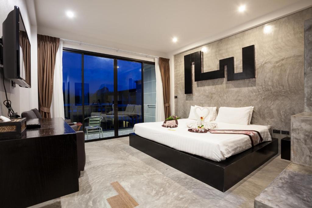 a bedroom with a king sized bed and a balcony at Aonang Viva Resort - SHA Plus in Ao Nang Beach