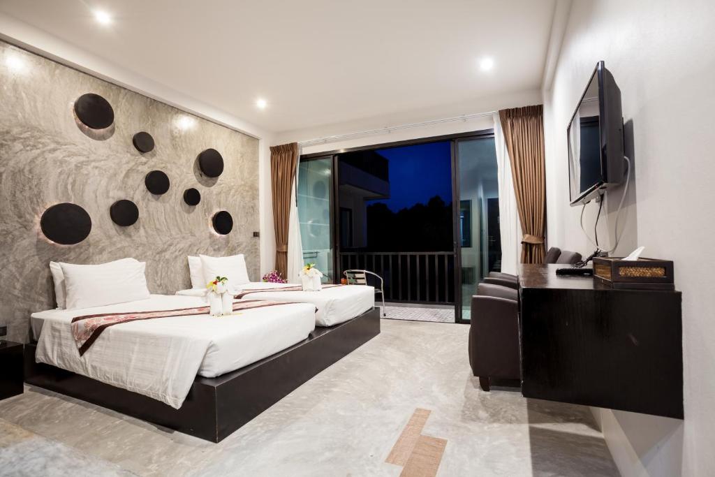 a bedroom with a large bed and a television at Aonang Viva Resort - SHA Plus in Ao Nang Beach