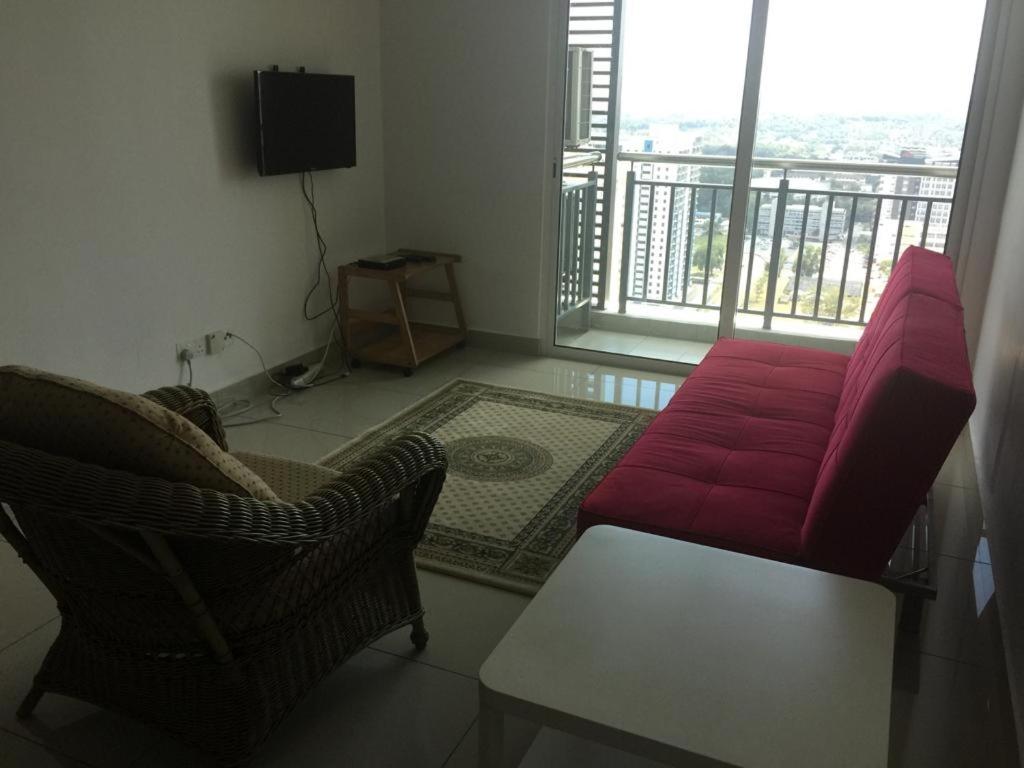 een woonkamer met een rode bank en een tafel bij DeCentrum Residences in Kajang