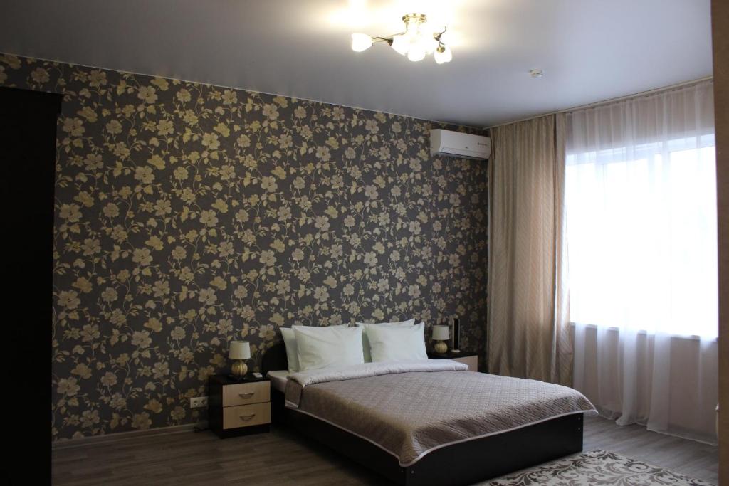 a bedroom with a bed with a floral wallpaper at Sofia Hotel in Perm