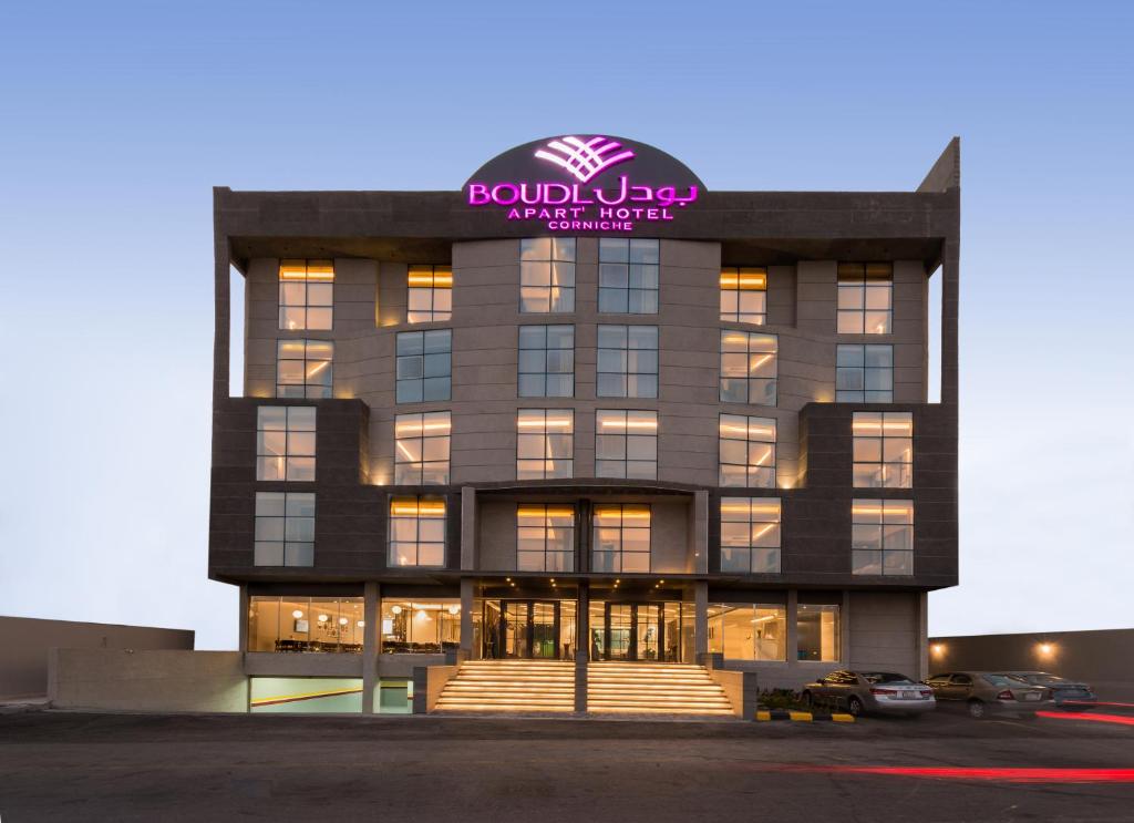 a building with a pink sign on top of it at Boudl Al Corniche in Dammam