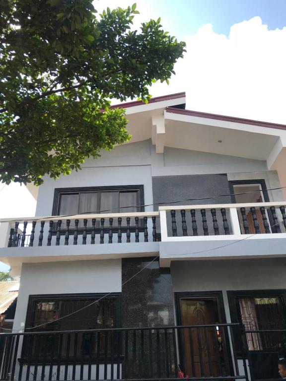 a white building with a balcony on it at Bangles Homestay in Coron