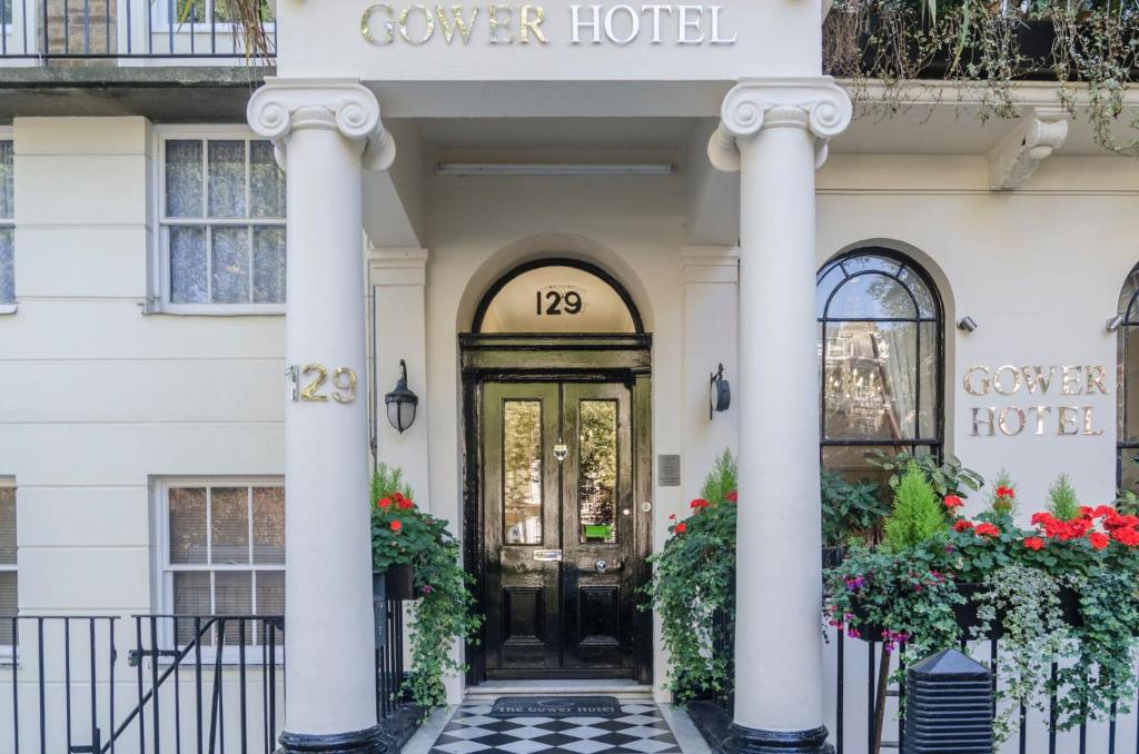 a hotel front door with columns and flowers at Aaraya Sussex Gardens in London