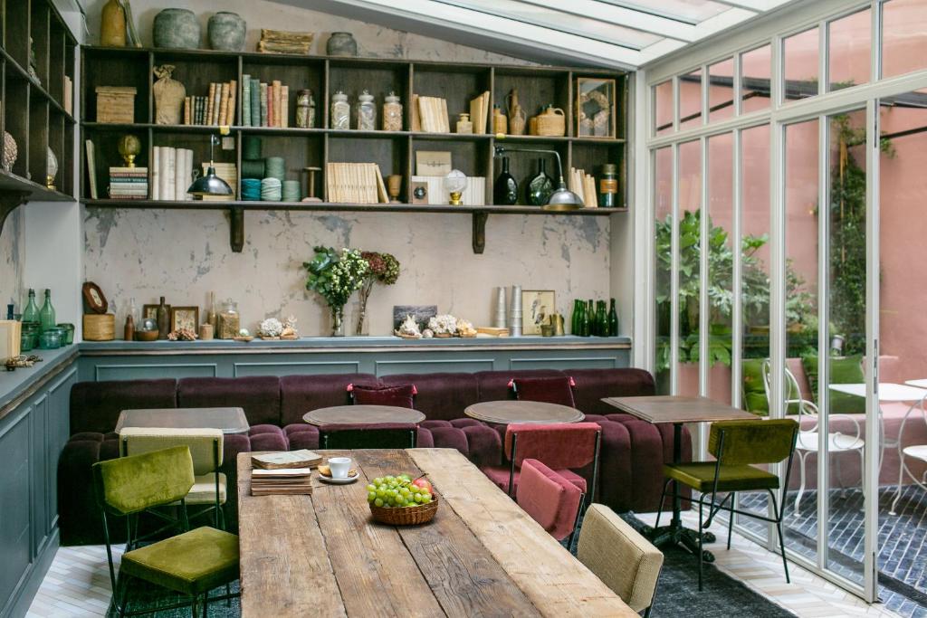 un restaurante con mesa de madera y sillas en La Planque Hotel, en París