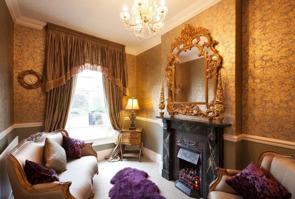 a living room with a fireplace and a mirror at The Villa in Robin Hoods Bay in Robin Hood's Bay