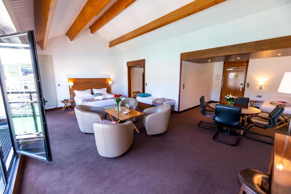 a hotel room with a bed and a living room at Hotel Le Grand Pavois in Fécamp