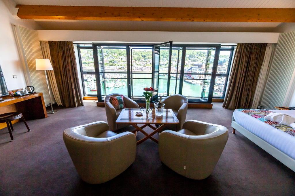 a hotel room with a table and chairs and a bed at Hotel Le Grand Pavois in Fécamp