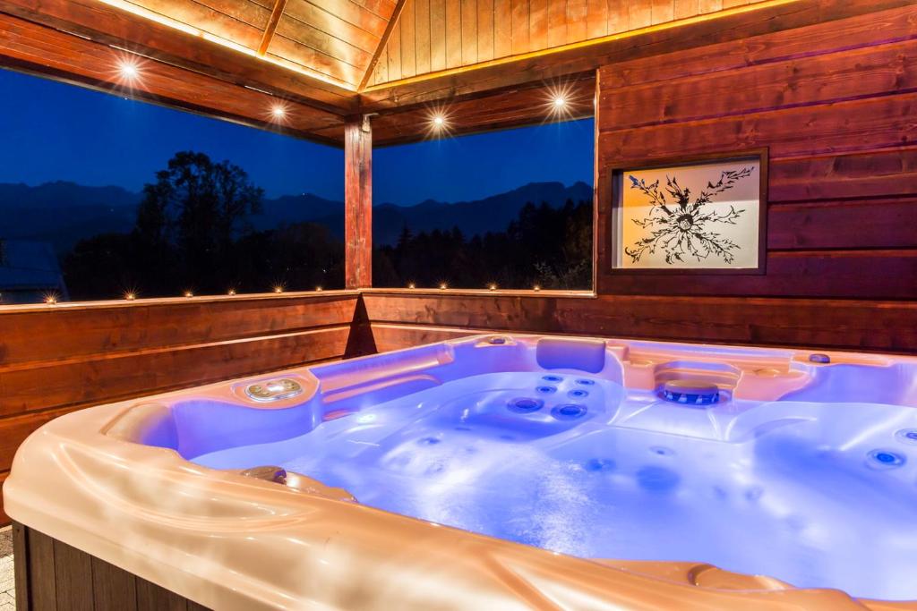 a jacuzzi tub in a room with a large window at Quality House - Cisza nad Doliną in Zakopane