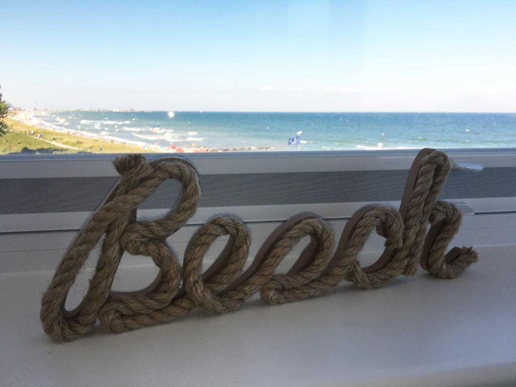 a pile of rope sitting in a window with a view of the ocean at Strandappartements Haus Strandkieker in Schönhagen