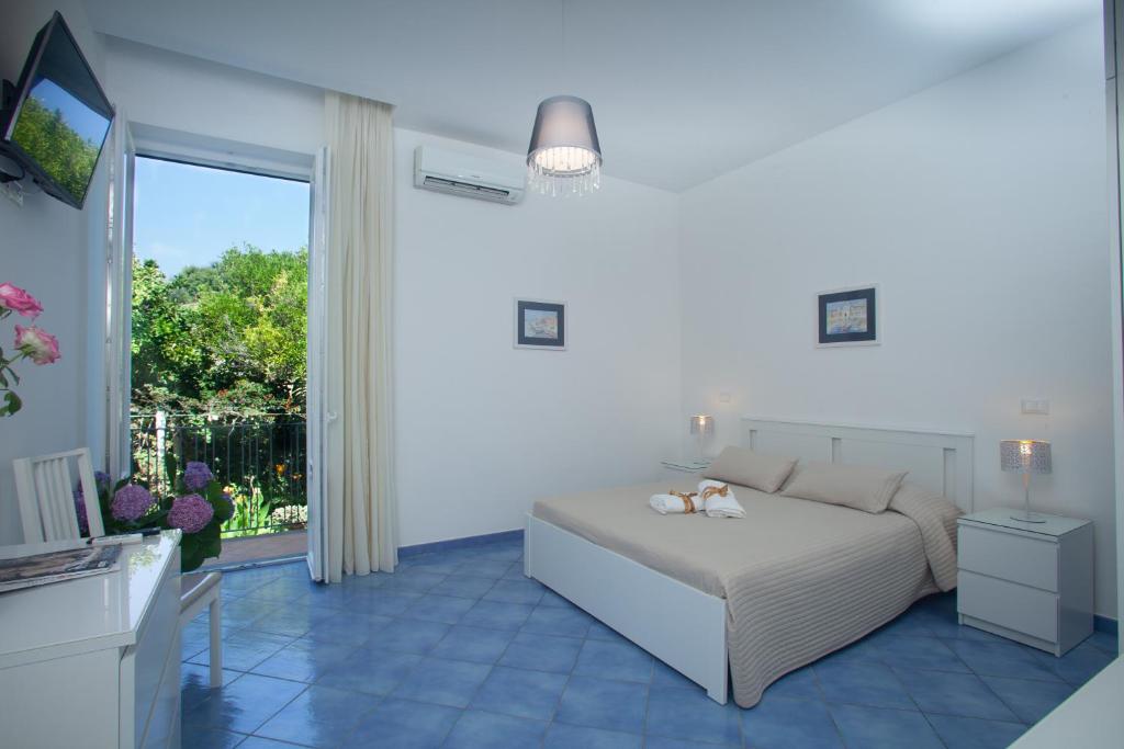 a white bedroom with a bed and a balcony at Hotel & Residence Matarese in Ischia