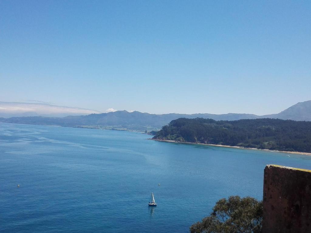 um barco no meio de um grande corpo de água em El Trasgu em Lastres