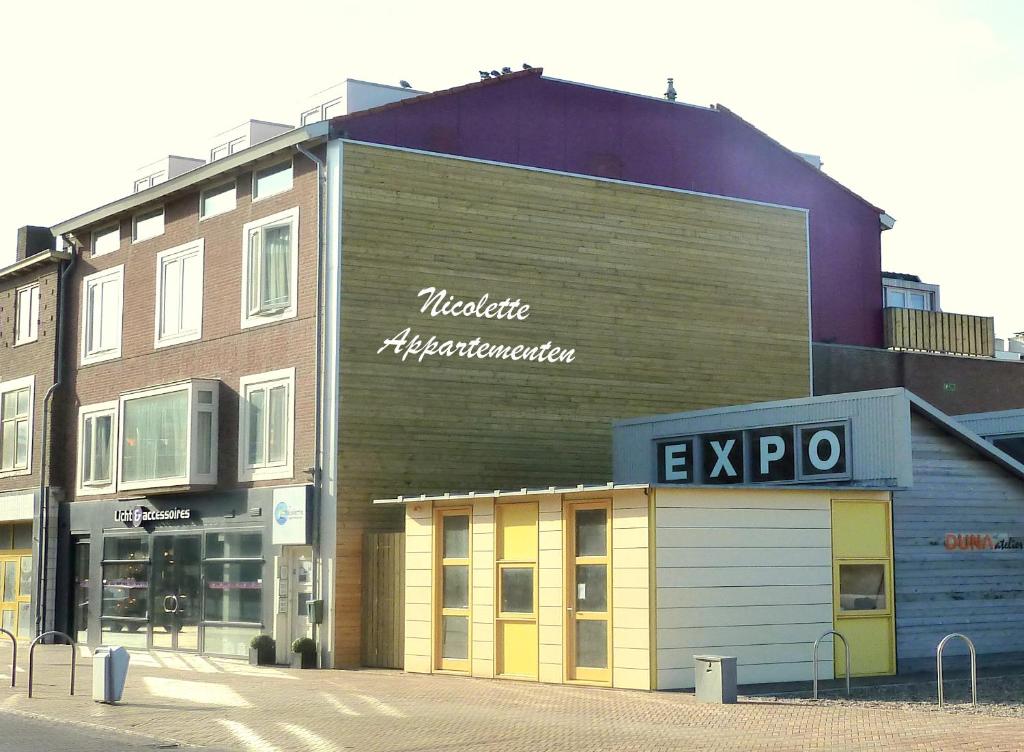 ein Gebäude mit einem Schild an der Seite in der Unterkunft Nicolette Apartments in Katwijk