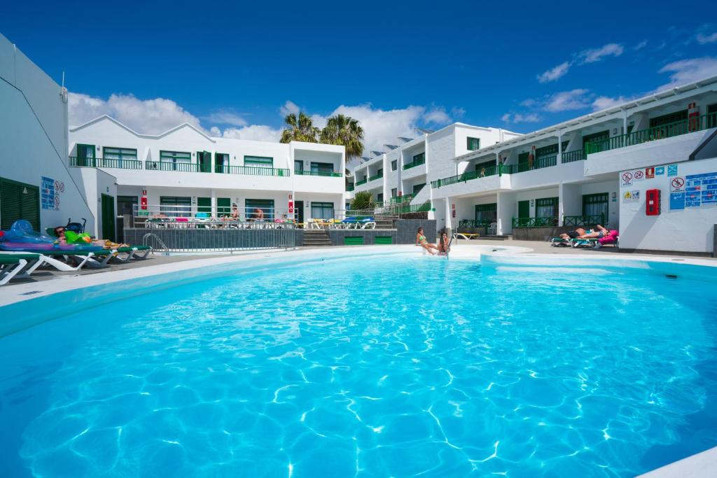 una gran piscina frente a algunos edificios en Apartamentos Elena, en Puerto del Carmen