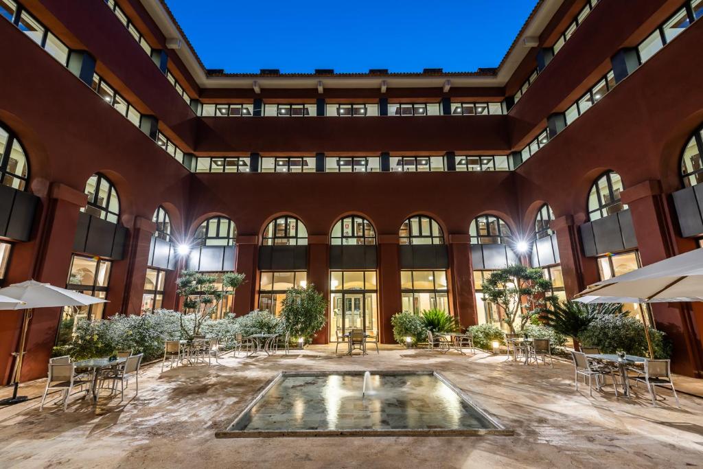 un cortile interno con tavoli e sedie in un edificio di Intelier Airén ad Alcazar de San Juan