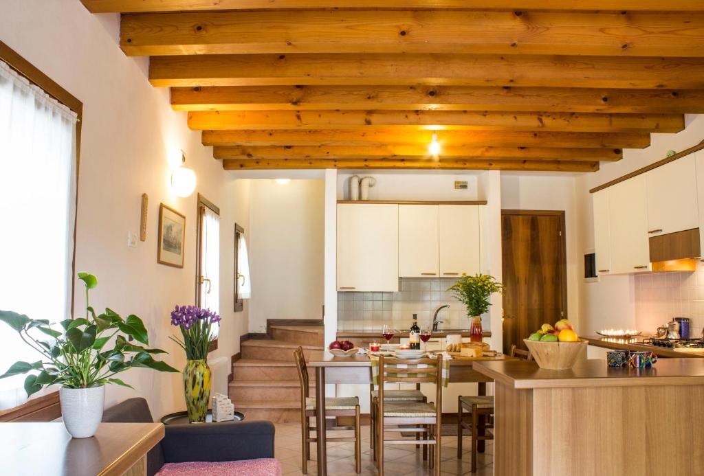 a kitchen and living room with wooden ceilings at Casetta Carmine in Asolo