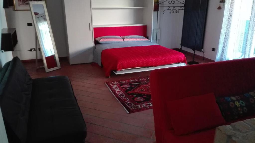 a bedroom with a red bed and a red couch at il Gelsomino appartamento turistico in Pesaro