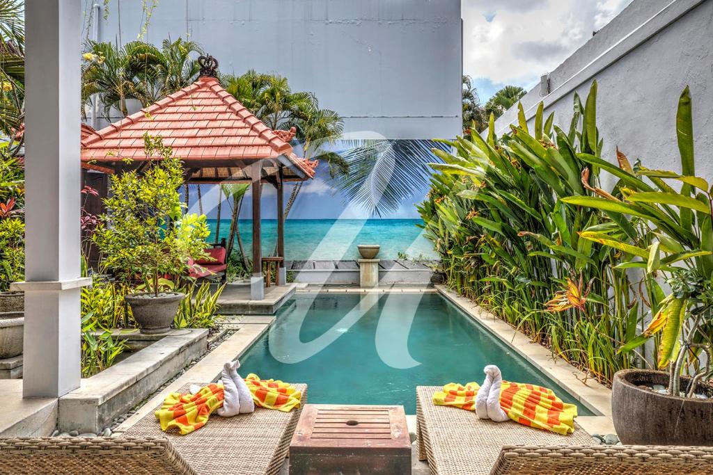 a swimming pool with a view of the ocean at Vila Ultima Bali in Seminyak