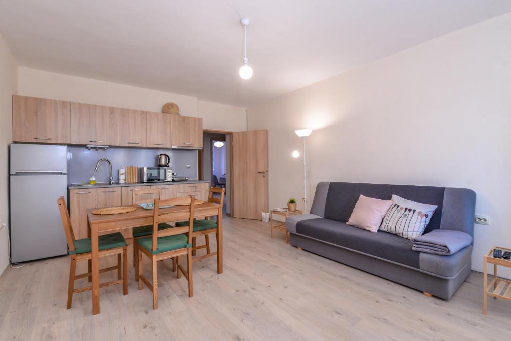 uma cozinha e uma sala de estar com um sofá e uma mesa em Atacama - spacious apartment in Lozenets area em Sófia