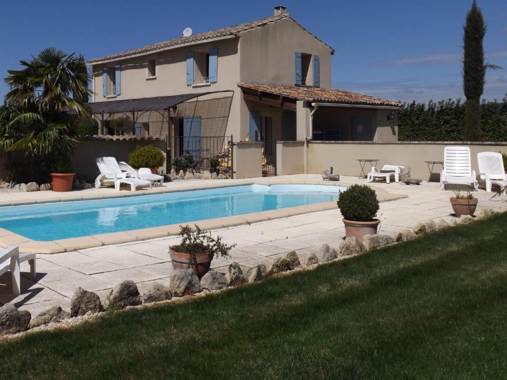 a swimming pool in front of a house at Demeure d'hôtes et Mas Maurice in Oppède