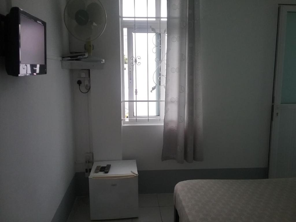 a small room with a bed and a window at La Plaine Verte Guesthouse in Port Louis