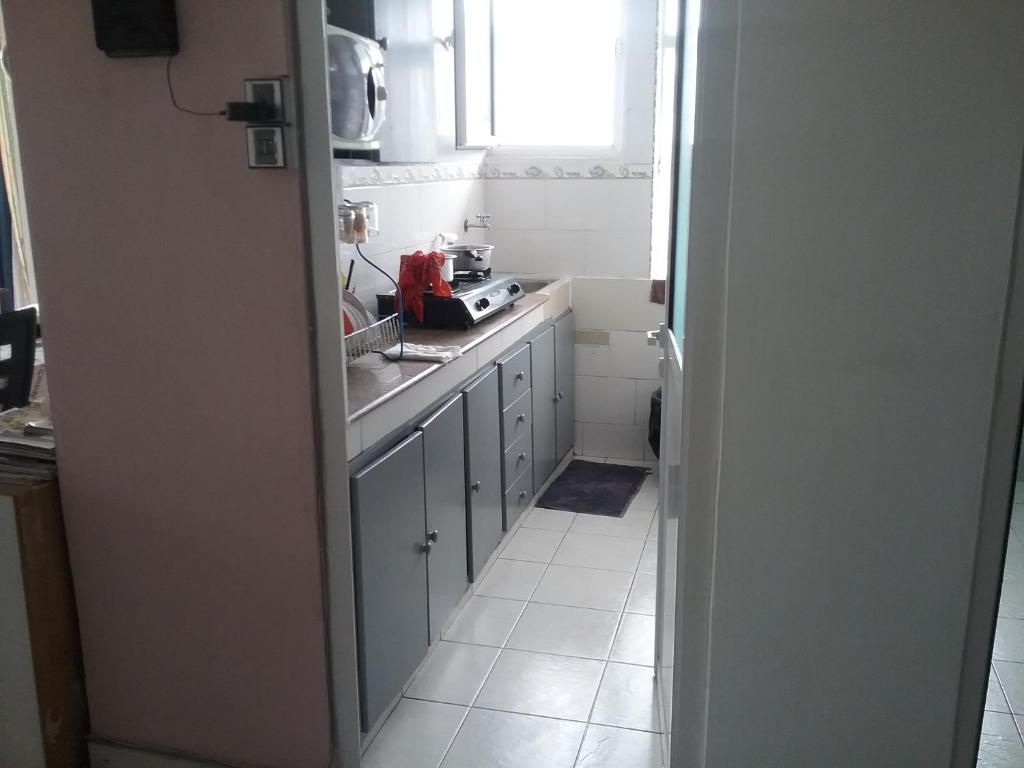 a small kitchen with a sink and a window at La Plaine Verte Guesthouse in Port Louis