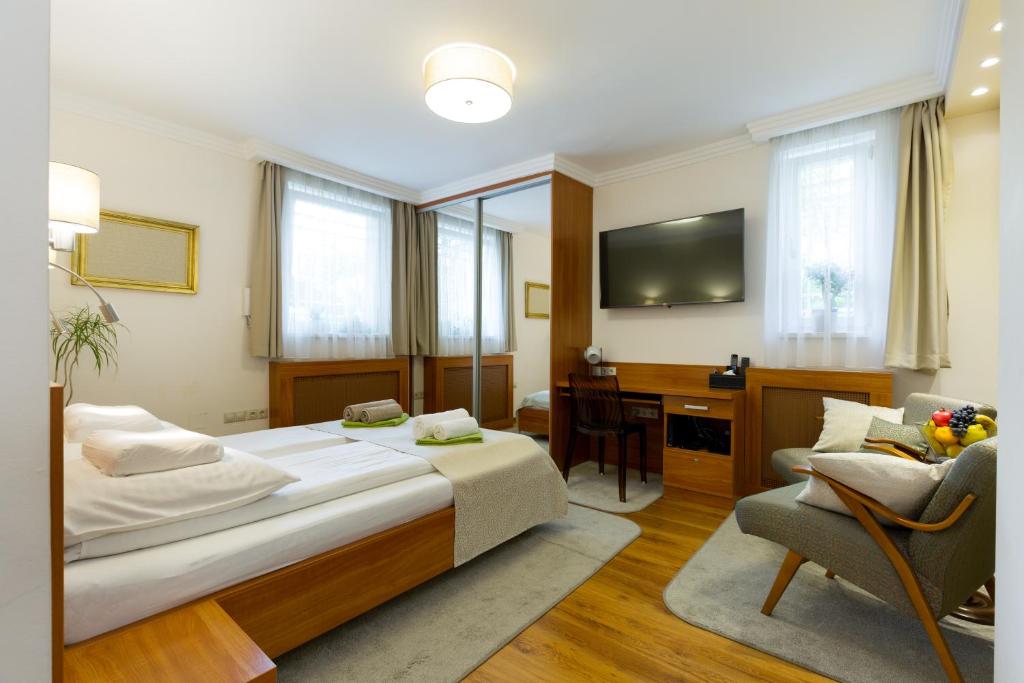 a bedroom with a bed and a desk and a chair at CityPark Villa Flat in Budapest