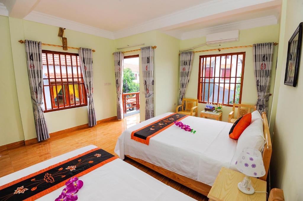 a bedroom with two beds and two windows at Tam Coc Tuan Minh Homestay in Ninh Binh