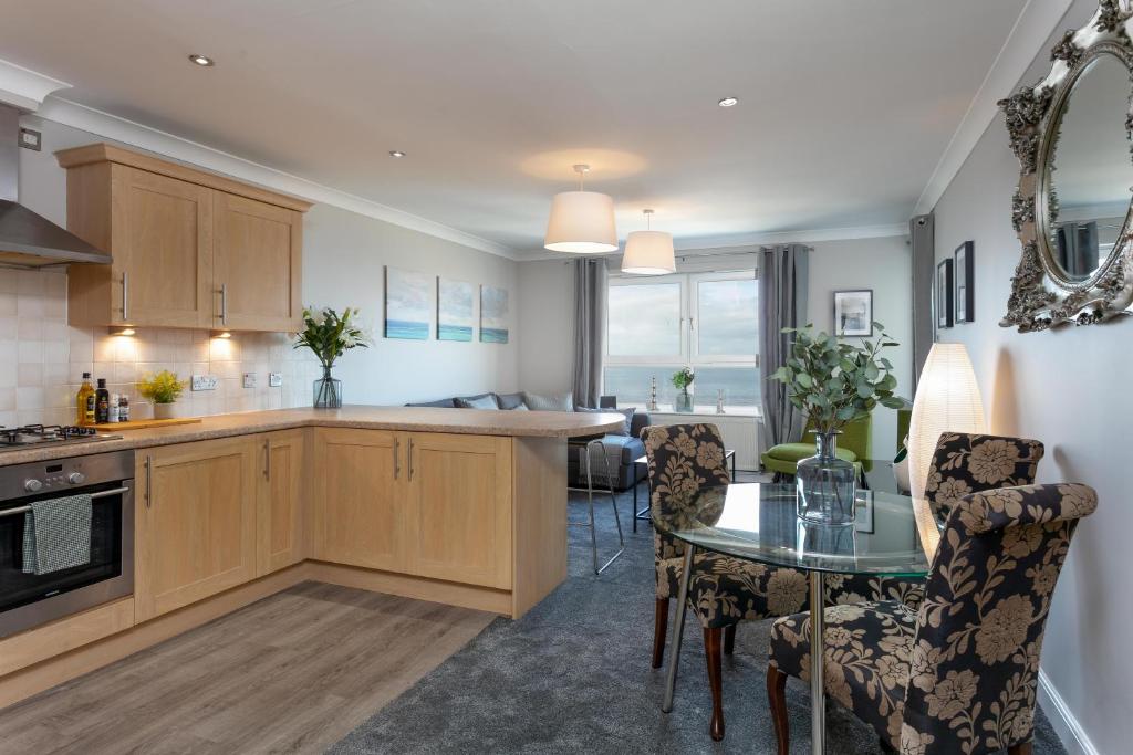 a kitchen and dining room with a table and chairs at Harris Retreat - Donnini Apartments in Ayr