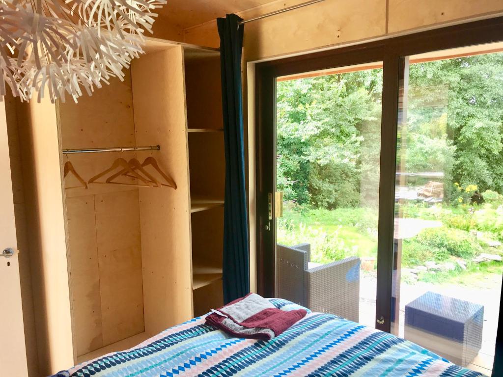 a room with a bed and a sliding glass door at Goleen Harbour Tiny House in Goleen