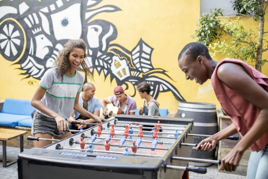 um grupo de pessoas jogando um jogo de pebolim em 91 Loop Boutique Hostel em Cidade do Cabo