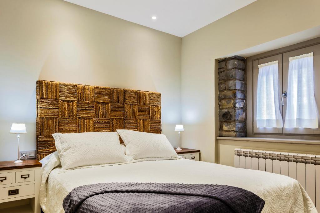 1 dormitorio con 1 cama grande y cabecero de madera en Casa Ríos, en Biescas