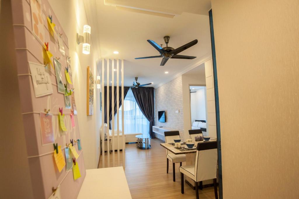 uma sala de estar com uma ventoinha de tecto e uma sala de jantar em The Wave Residence Melaka Kota Laksamana em Malaca