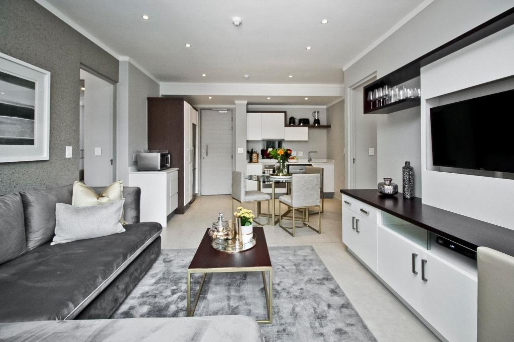 een woonkamer met een bank en een tafel bij SANDTON APARTMENT 15 WEST ROAD SOUTH in Johannesburg