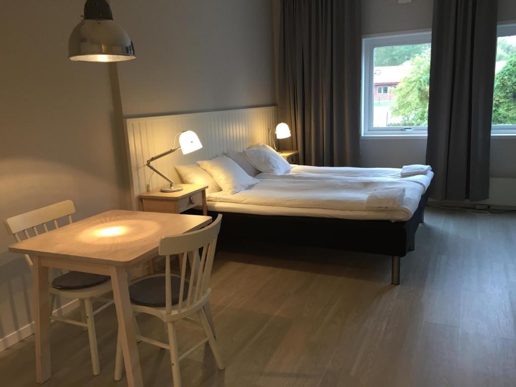a bedroom with a bed and a table and a table and chairs at Vallabiten Rum och Lägenheter in Växjö