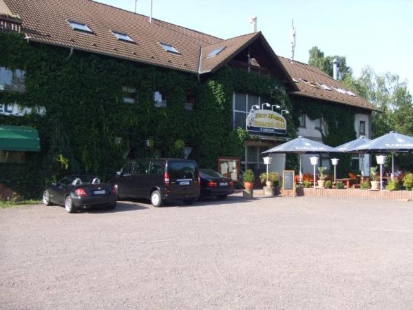 two cars parked in a parking lot in front of a building at Hotel Restaurant Zur Hexe in Überherrn