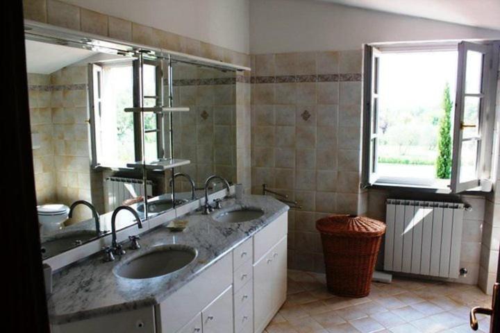 a bathroom with two sinks and two windows at La Cascina nel Roseto in Rigutino