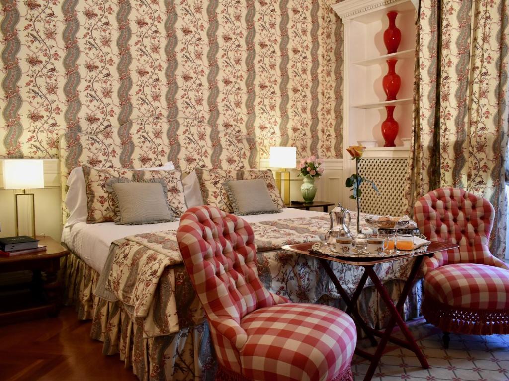 een kamer met een bed en een tafel en stoelen bij Palazzina Mori - Luxury B&B in San Donà di Piave