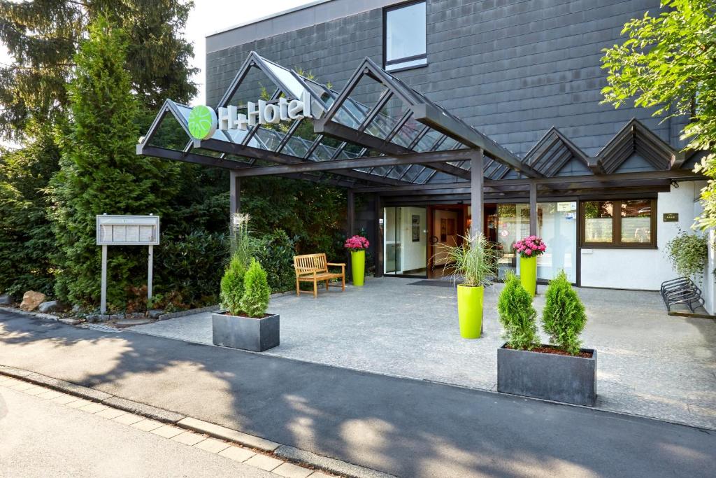 ein Gebäude mit einer Treppe und Pflanzen davor in der Unterkunft H+ Hotel Goslar in Goslar
