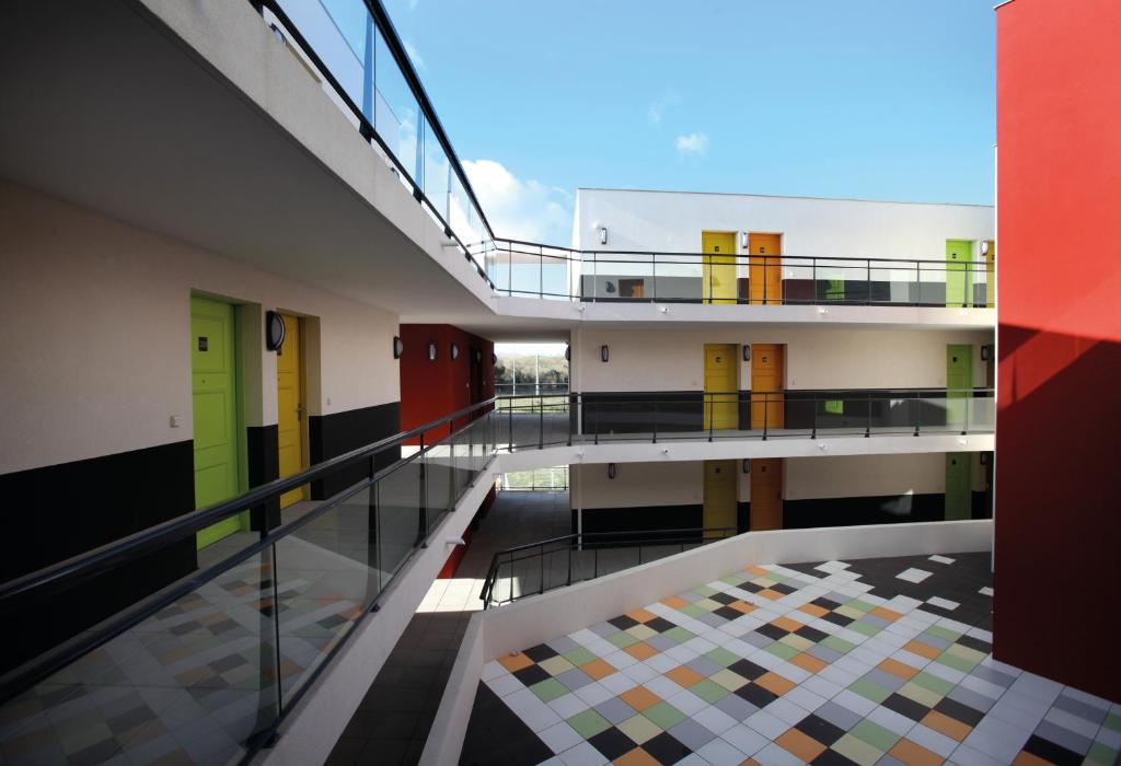 Résidence Les Portes d'Espagne في بيربينيا: إطلالة من الطابق الثاني على مبنى وأرضيات ملونة