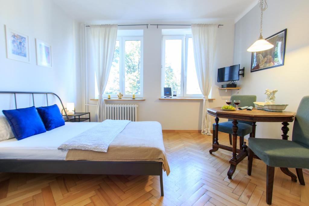 a bedroom with a bed and a table and a chair at Rental Apartments Bednarska in Warsaw