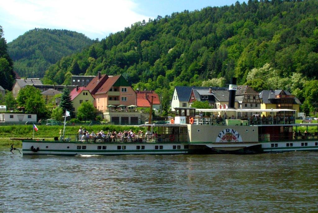 un gran barco en el agua con gente en él en Ferienappartements Elbaussicht - Krippen, en Bad Schandau