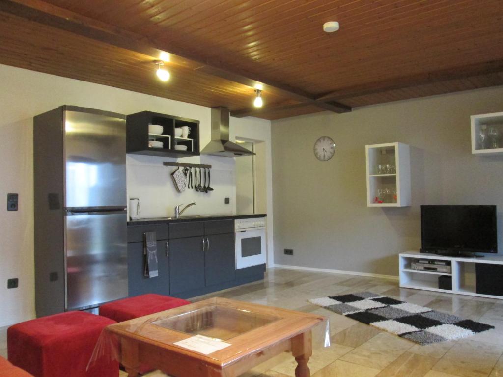 ein Wohnzimmer mit einem Tisch und einem Kühlschrank in der Unterkunft Ferienwohnung Edi Fischer in Oberfell