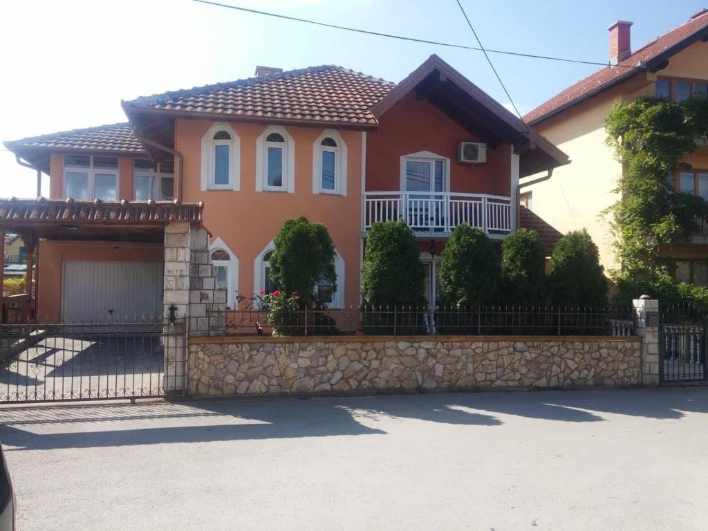 a house with a stone fence in front of it at GuestHouse in Sarajevo