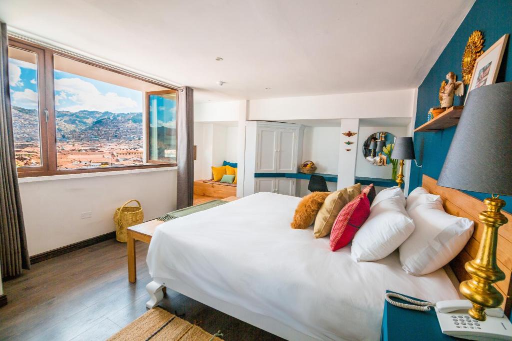 1 dormitorio con 1 cama blanca grande y ventana grande en Tariq Boutique, en Cusco