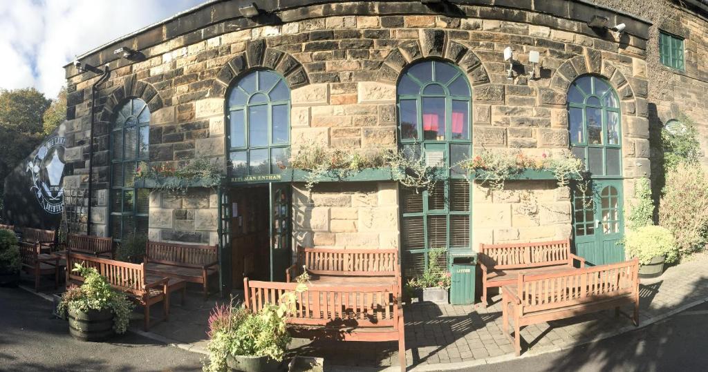 a stone building with benches in front of it at The Keelman and Big Lamp Brewery in Newcastle upon Tyne