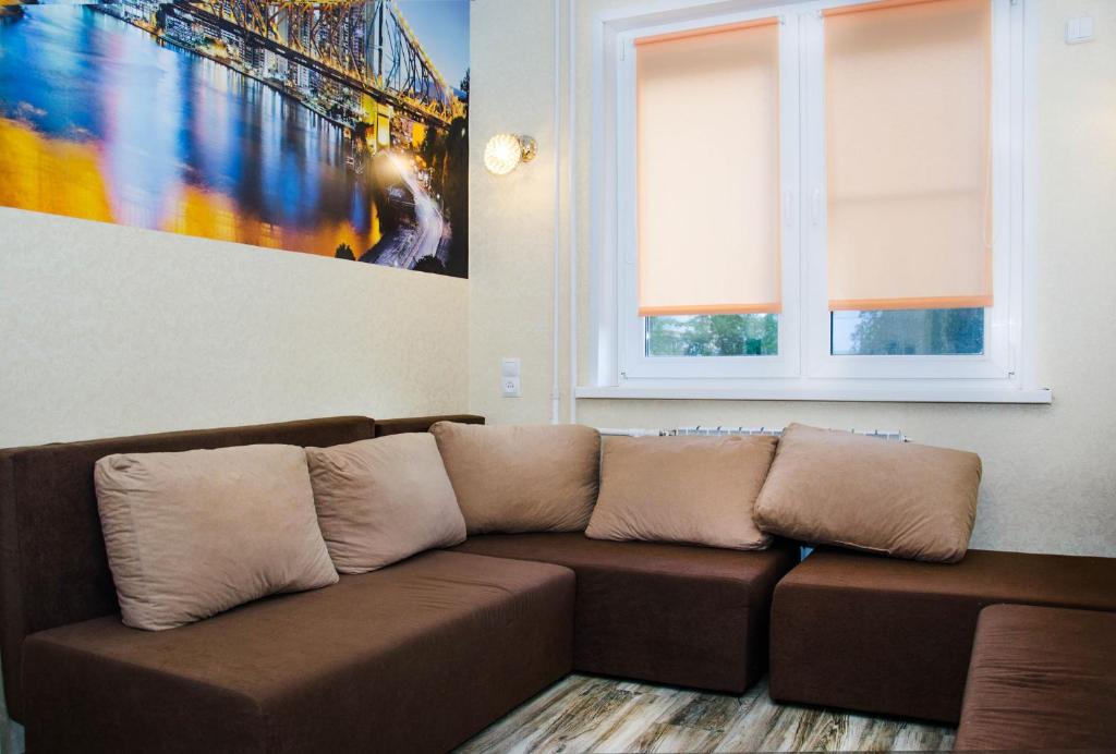 トゥーラにあるСтудия в самом центре Тулыの絵画のあるリビングルームに茶色のソファ
