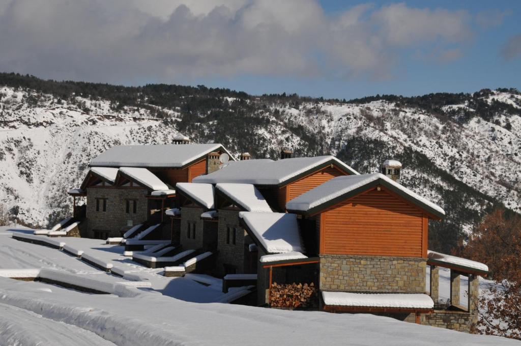 a row of cabins with snow on the roofs at Pallas Casa in Panagía