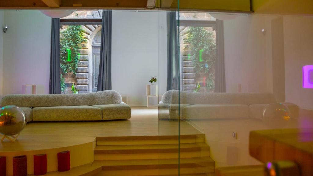 Orvieto Templari Suite في أورفييتو: غرفة معيشة بها كنبتين وطاولة زجاجية