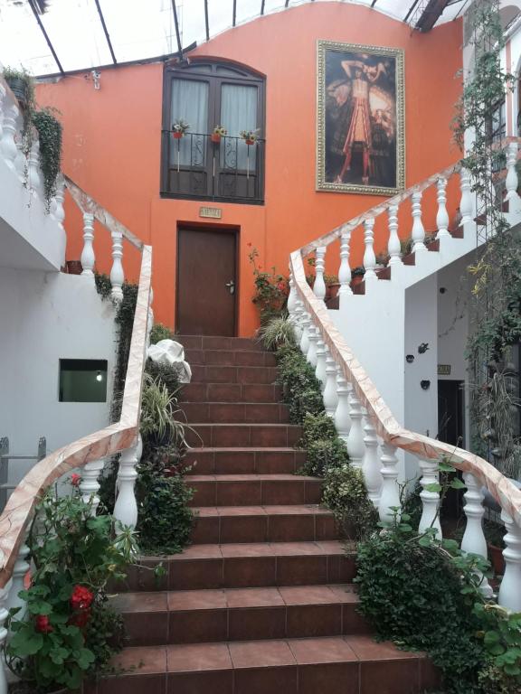 un escalier menant à un bâtiment aux murs orange dans l'établissement Hostal Tukos La Casa Real, à Potosí